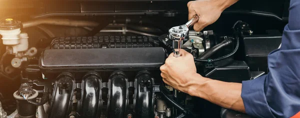 Otomobil tamircisi elleri ingiliz anahtarı, araba servisi ve bakımı ile bir araba motoru otomotiv atölyesini tamir ediyor..