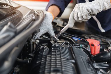 Otomobil tamircisi elleri ingiliz anahtarı, araba servisi ve bakımı ile bir araba motoru otomotiv atölyesini tamir ediyor..