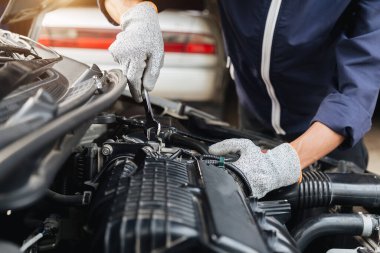 Otomobil tamircisi elleri ingiliz anahtarı, araba servisi ve bakımı ile bir araba motoru otomotiv atölyesini tamir ediyor..