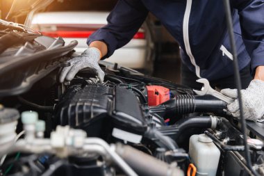 Otomobil tamircisi elleri ingiliz anahtarı, araba servisi ve bakımı ile bir araba motoru otomotiv atölyesini tamir ediyor..