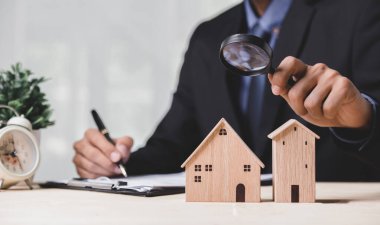 Buy or Rent 'le çalışan iş adamı, kopyalama alanı. Mülk yatırımı ve ev kredisi finansal konsepti El 'in ahşap eve para yığını koyması..