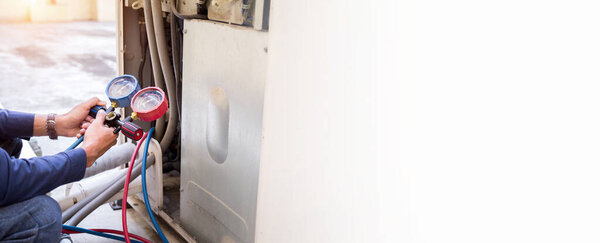 Technician is checking air conditioner ,measuring equipment for filling air conditioners.