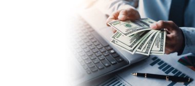 Elinde para, Amerikan doları, yatırımı, başarısı ve karlı iş kavramları olan bir iş adamı.