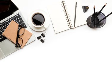 Üst kattaki ofis masasında yatıyordu. Çalışma alanı boş, ofis malzemeleri, kalem, yeşil yaprak ve beyaz arka planda kahve fincanı. .