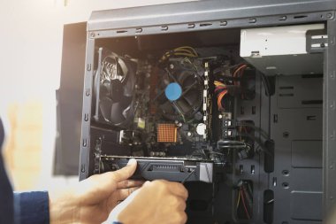 Bilgisayarları tamir etmek için tornavidayla çalışan bir teknisyen.;