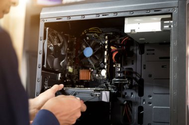 Bilgisayarları tamir etmek için tornavidayla çalışan bir teknisyen.;