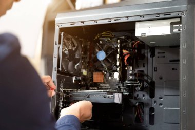 Bilgisayarları tamir etmek için tornavidayla çalışan bir teknisyen.;