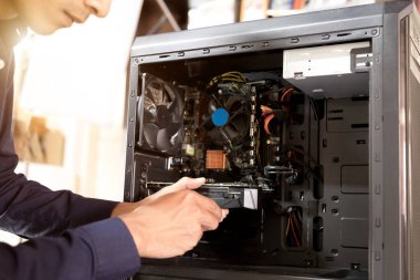 Bilgisayarları tamir etmek için tornavidayla çalışan bir teknisyen.;