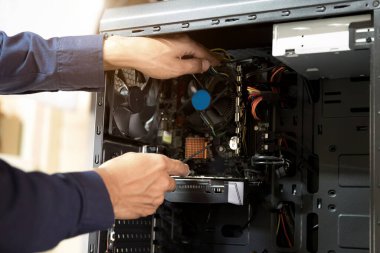 Bilgisayarları tamir etmek için tornavidayla çalışan bir teknisyen.;