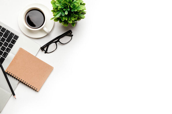 Flat lay, top view office table desk. Workspace with blank, office supplies, pencil, green leaf, and coffee cup on white background .