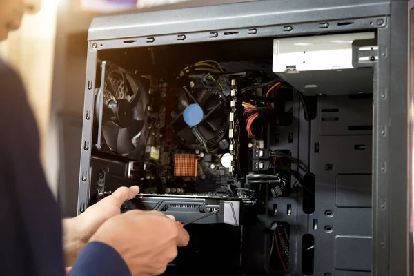 Bilgisayarları tamir etmek için tornavidayla çalışan bir teknisyen.;
