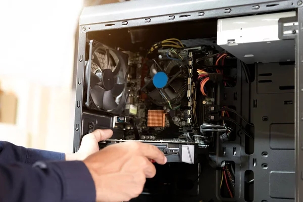 Bilgisayarları tamir etmek için tornavidayla çalışan bir teknisyen.;