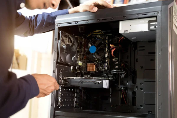 Bilgisayarları tamir etmek için tornavidayla çalışan bir teknisyen.;