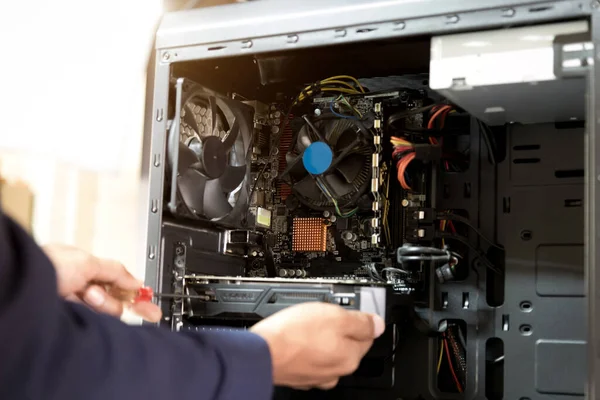 Bilgisayarları tamir etmek için tornavidayla çalışan bir teknisyen.;