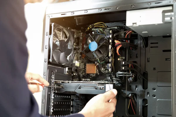 Bilgisayarları tamir etmek için tornavidayla çalışan bir teknisyen.;