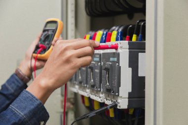 Elektrik mühendisi, kabine kontrolündeki voltaj ve elektrik hattının akımını ölçen bir testçi..