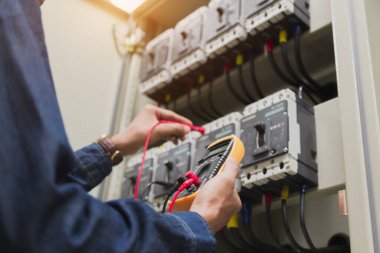 Elektrik mühendisi, kabine kontrolündeki voltaj ve elektrik hattının akımını ölçen bir testçi..