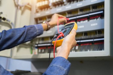 Elektrik mühendisi, kabine kontrolündeki voltaj ve elektrik hattının akımını ölçen bir testçi..