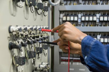 Elektrik mühendisi, kabine kontrolündeki voltaj ve elektrik hattının akımını ölçen bir testçi..