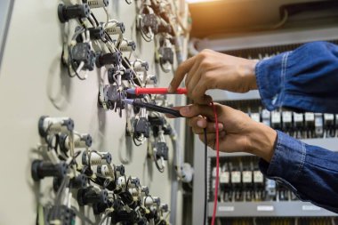 Elektrik mühendisi, kabine kontrolündeki voltaj ve elektrik hattının akımını ölçen bir testçi..