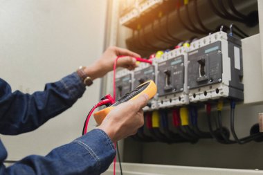 Elektrik mühendisi, kabine kontrolündeki voltaj ve elektrik hattının akımını ölçen bir testçi..
