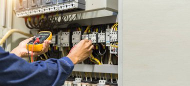 Elektrik mühendisi, kabine kontrolündeki voltaj ve elektrik hattının akımını ölçen bir testçi..