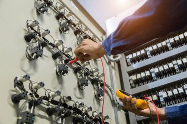 Elektrik mühendisi, kabine kontrolündeki voltaj ve elektrik hattının akımını ölçen bir testçi..
