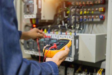 Elektrik mühendisi, kabine kontrolündeki voltaj ve elektrik hattının akımını ölçen bir testçi..