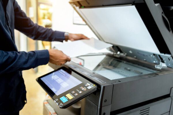Bussiness man Hand press button on panel of printer, printer scanner laser office copy machine supplies start concept.
