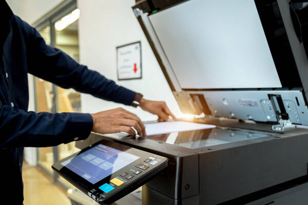 Bussiness man Hand press button on panel of printer, printer scanner laser office copy machine supplies start concept.