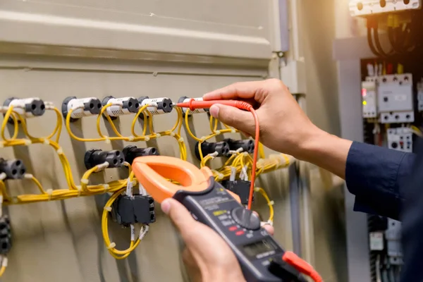 Kontrol panelinde çoklu metre test cihazı olan elektrikçi ölçümleri.