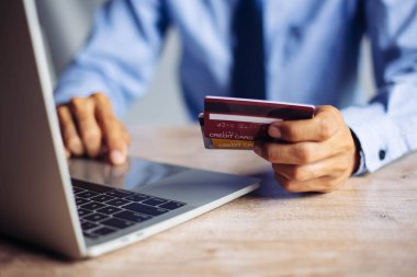 Online payment hands holding credit card and using laptop.