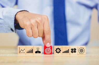 İş başarısı hedefleri kavramı. Yaratıcılık için ahşap küp bloğuna baskı yapan ve iş hedefi hedef kavramı oluşturan el ele tutuşan hedef tahtası, fikirler oluşturmak için engeller, hedef belirleme.