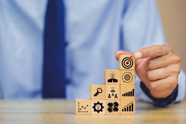 İş başarısı hedefleri kavramı. Yaratıcılık için ahşap küp bloğuna baskı yapan ve iş hedefi hedef kavramı oluşturan el ele tutuşan hedef tahtası, fikirler oluşturmak için engeller, hedef belirleme.