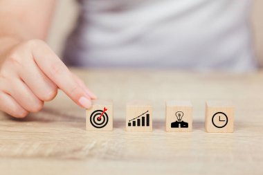 İş başarısı hedefleri kavramı. Yaratıcılık için ahşap küp bloğuna baskı yapan ve iş hedefi hedef kavramı oluşturan el ele tutuşan hedef tahtası, fikirler oluşturmak için engeller, hedef belirleme.