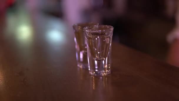 Пара білих рук починає класти склянки на барну стійку за раз — стокове відео