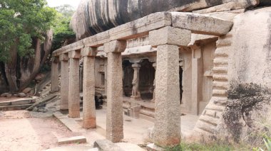 Mağaranın arka planında sütunları ve manzarası olan kayalara oyulmuş mağara taşı salonu.