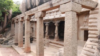 Mağaranın arka planında sütunlar olan kayalara oyulmuş mağara taşı salonu. bir kenar görünüm