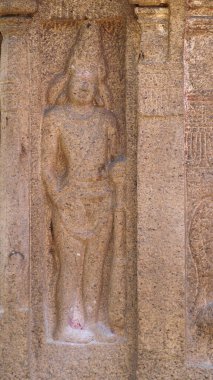 Kayaya oyulmuş antik heykel. Kaya arka planda yer alıyor.