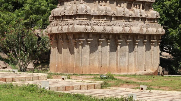Taşa kazınmış bir tapınak. Ve içinde bir sürü heykel var. Doğal arka planda yer alıyor. Bir kenar görünüm.