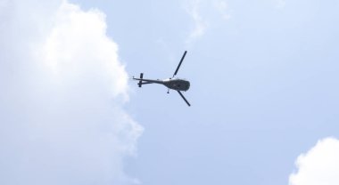 Gökyüzünde bir helikopter var. Loş gökyüzünün arkaplanına karşı