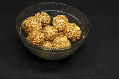 Tatlı susamlı toplar bir fincanda. Siyah bir arkaplanda