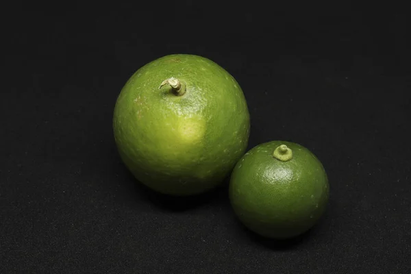 緑のレモンフルーツ 黒い背景の上に — ストック写真