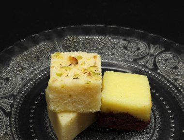 Tabakta kare şeklinde şekerler. Siyah bir arkaplanda