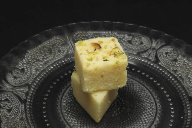 Tabakta kare şeklinde şekerler. Siyah bir arkaplanda