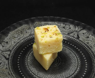 Tabakta kare şeklinde şekerler. Siyah bir arkaplanda