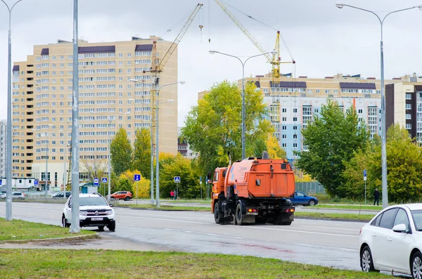 Очистка городских улиц с помощью специальной апельсиновой поливочной машины. — стоковое фото