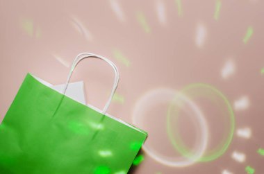 İçinde bir hediye olan yeşil paket, beyaz bir kutu, ışık halkaları ve ışınların arka planına karşı. Düz yat, boşluğu kopyala.
