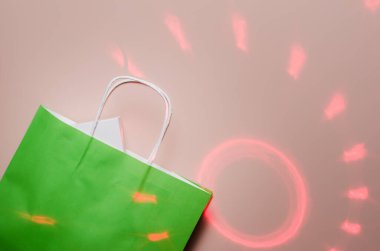 İçinde bir hediye olan yeşil paket, beyaz bir kutu, ışık halkaları ve ışınların arka planına karşı. Düz yat, boşluğu kopyala.