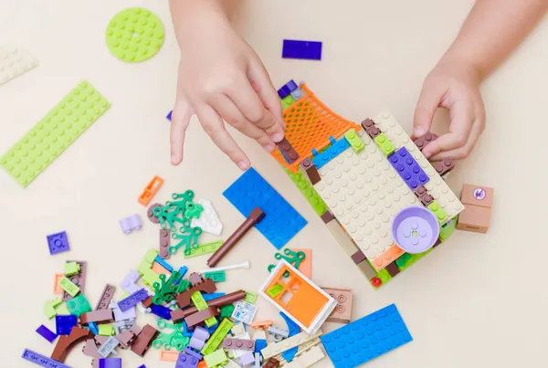 Ульяновск, Россия, 15 ноября 2021 года: ребенок в возрасте 5 лет собирает дом от маленьких красочных частей друзей-конструкторов Лего. концепция — стоковое фото